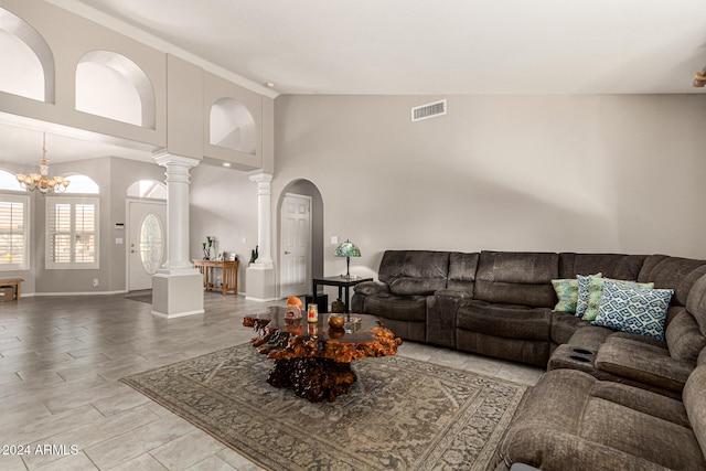 living room featuring high vaulted ceiling and an inviting chandelier