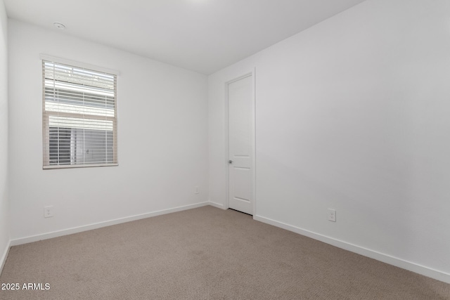 spare room featuring light colored carpet