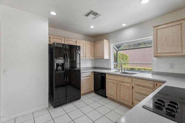 kitchen featuring black appliances, light brown cabinets, light tile patterned floors, and sink