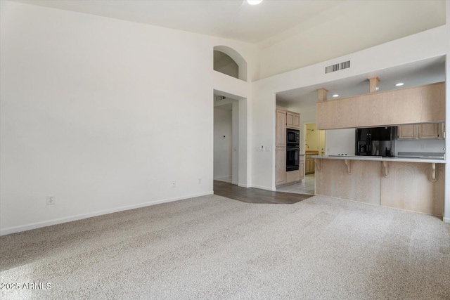 unfurnished living room featuring light carpet