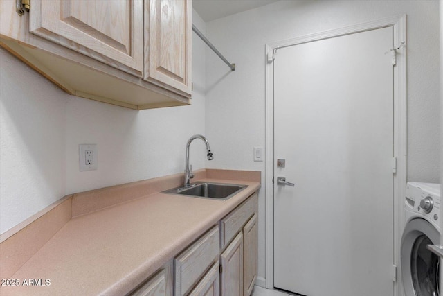 washroom featuring cabinets, sink, and washer / clothes dryer