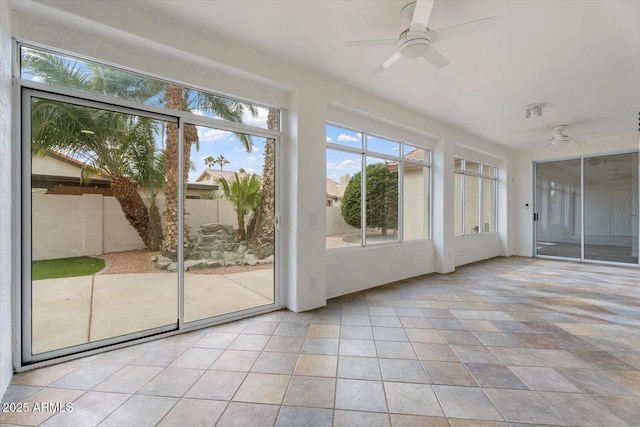 unfurnished sunroom featuring ceiling fan