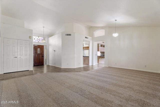 unfurnished living room with carpet floors, high vaulted ceiling, and a notable chandelier