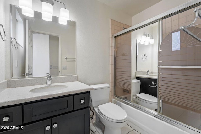 full bathroom with shower / bath combination with glass door, tile patterned floors, vanity, and toilet