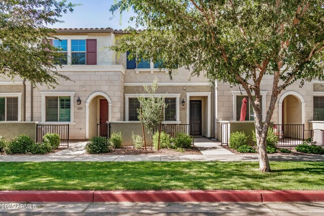 1825 E Hampton Ln Unit 108, Gilbert, AZ 85295 - view of property featuring a fenced front yard, stucco siding, and stone siding