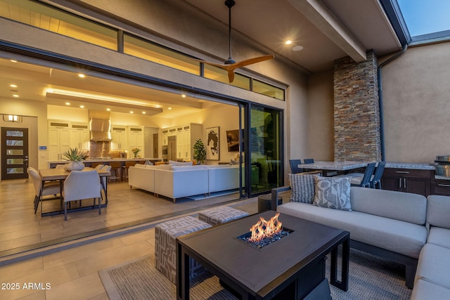 view of patio with outdoor dining area, an outdoor living space with a fire pit, and ceiling fan