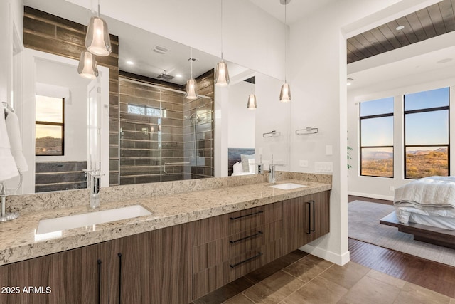 full bath with baseboards, a sink, ensuite bath, and double vanity