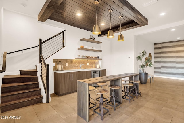 bar with pendant lighting, backsplash, wet bar, wooden ceiling, and stairs