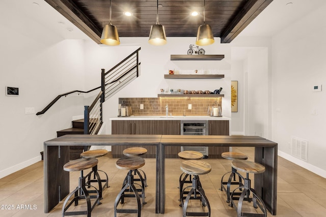 bar featuring beverage cooler, visible vents, stairway, wet bar, and backsplash