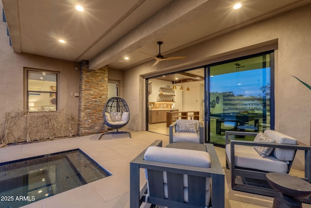 patio terrace at dusk featuring outdoor lounge area and a ceiling fan