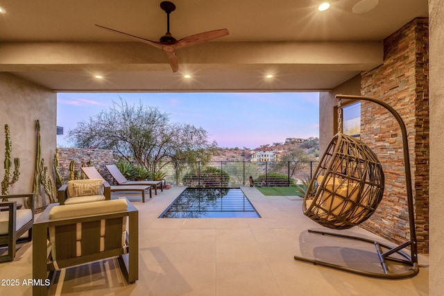 view of patio with ceiling fan and fence