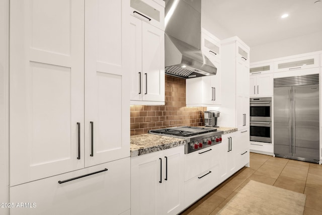 kitchen featuring glass insert cabinets, white cabinetry, appliances with stainless steel finishes, and extractor fan