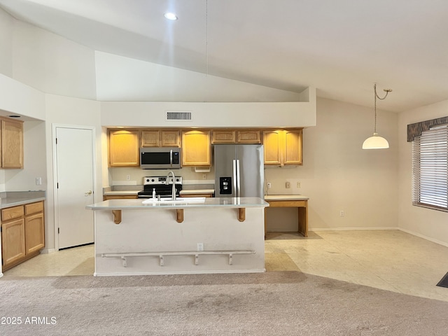 kitchen featuring decorative light fixtures, stainless steel appliances, a kitchen island with sink, and sink