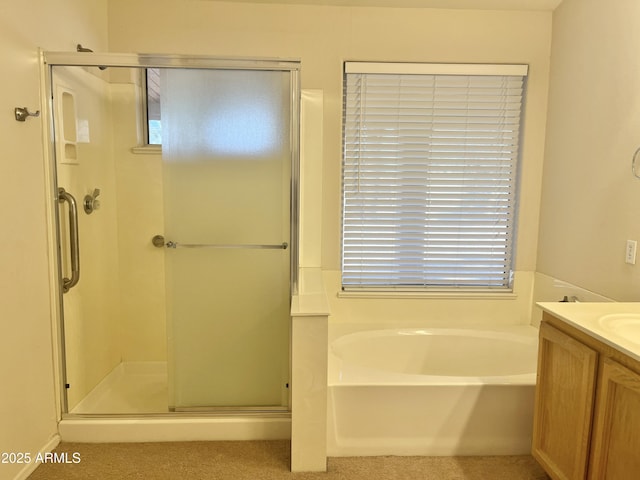 bathroom with vanity and shower with separate bathtub