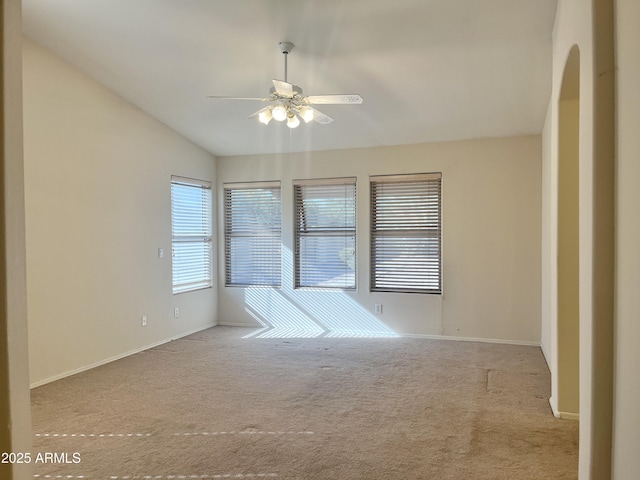 carpeted empty room featuring ceiling fan and vaulted ceiling