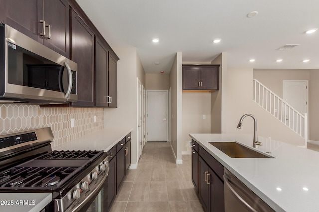 9412 E Sequence Ave, Mesa, AZ 85212 - kitchen with stainless steel appliances, tasteful backsplash, dark brown cabinets, light countertops, and recessed lighting