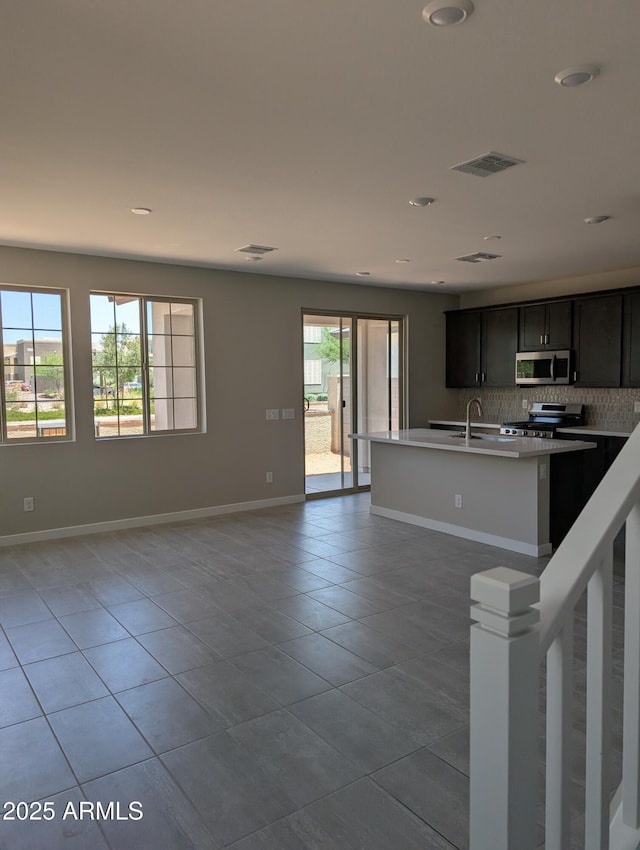 9412 E Sequence Ave, Mesa, AZ 85212 - kitchen featuring appliances with stainless steel finishes, light tile patterned flooring, backsplash, open floor plan, and recessed lighting