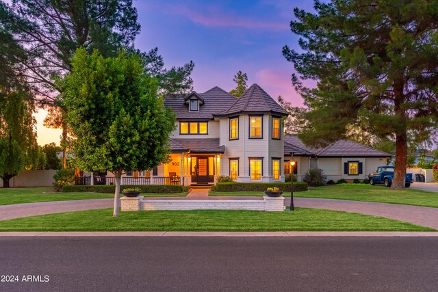 victorian-style house featuring covered porch and a front yard