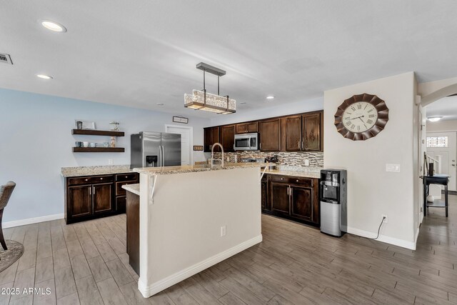 308 E Sheffield Ct, Gilbert, AZ 85296 - kitchen with appliances with stainless steel finishes, open shelves, arched walkways, light wood-style flooring, and dark brown cabinets