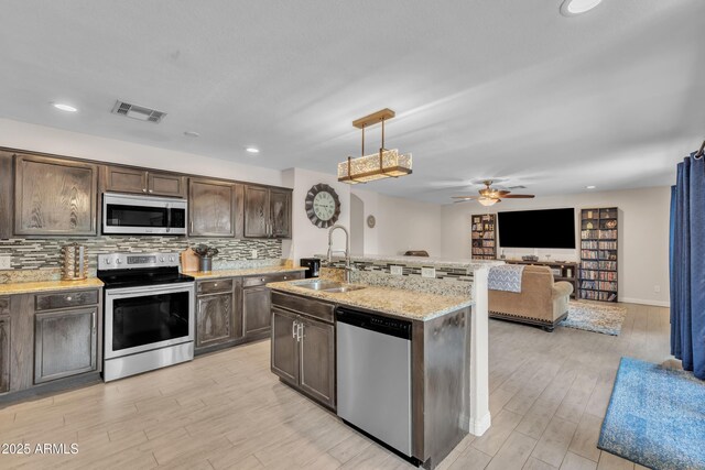 308 E Sheffield Ct, Gilbert, AZ 85296 - kitchen with appliances with stainless steel finishes, ceiling fan, light wood-style floors, open floor plan, and dark brown cabinetry