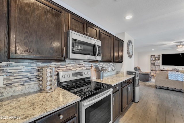 308 E Sheffield Ct, Gilbert, AZ 85296 - kitchen featuring appliances with stainless steel finishes, dark brown cabinets, open floor plan, ceiling fan, and tasteful backsplash