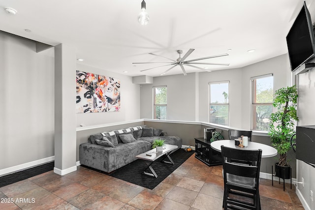 living area with recessed lighting, stone finish flooring, and baseboards