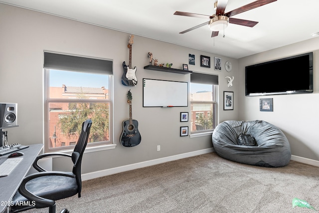 carpeted office space with a ceiling fan, a healthy amount of sunlight, and baseboards