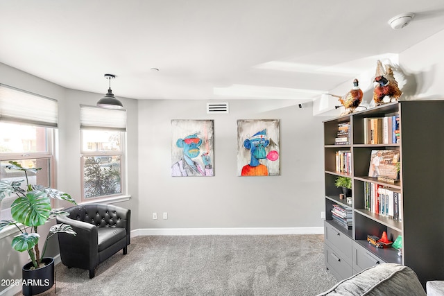 living area with visible vents, baseboards, and carpet flooring