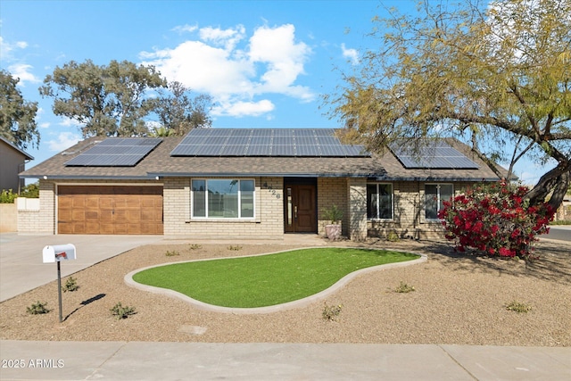 ranch-style home with solar panels and a garage