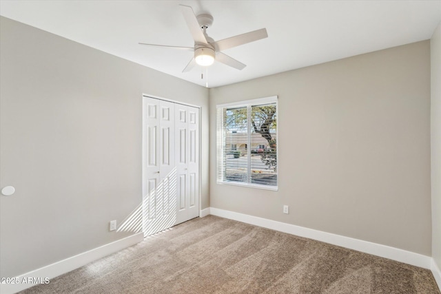 unfurnished bedroom with light carpet, a closet, and ceiling fan