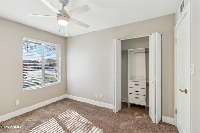 unfurnished bedroom featuring multiple windows, a closet, ceiling fan, and dark carpet