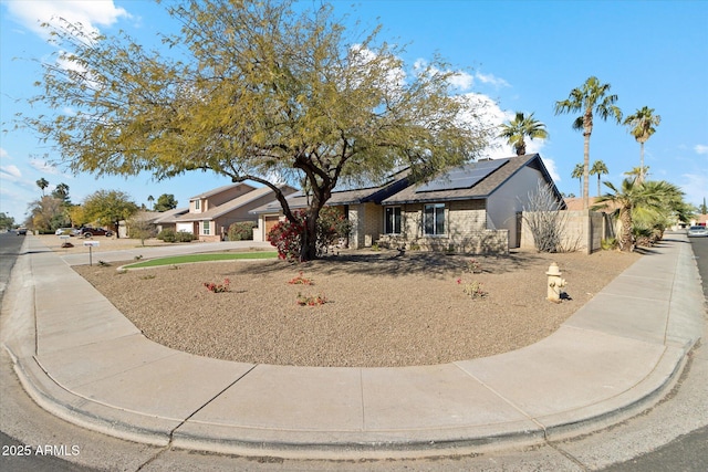 ranch-style house featuring solar panels