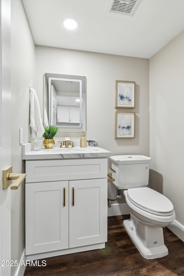 bathroom featuring hardwood / wood-style floors, vanity, and toilet