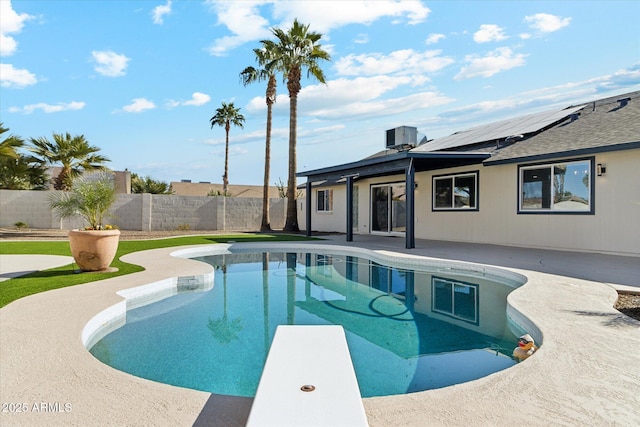 view of swimming pool with a diving board and a patio area