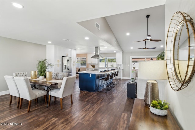 dining space featuring lofted ceiling, ceiling fan, and dark wood-type flooring