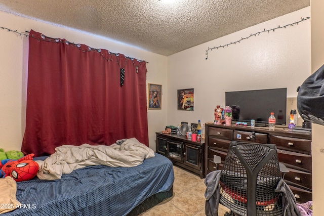bedroom with a textured ceiling and light tile patterned floors