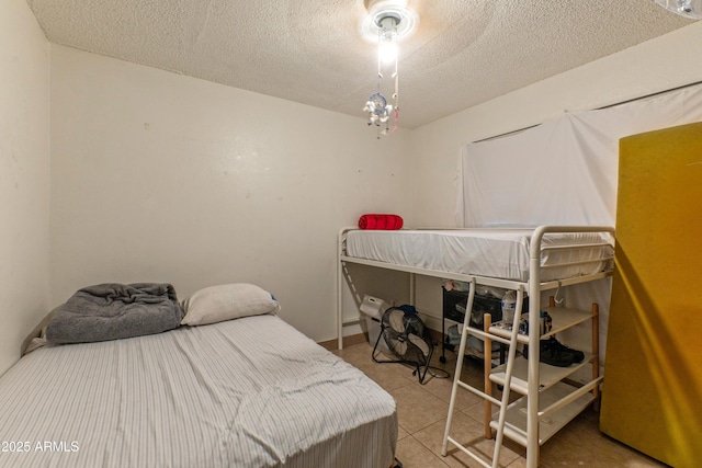 bedroom featuring light tile patterned floors and a textured ceiling