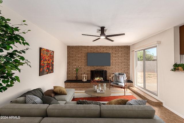 tiled living room featuring a brick fireplace, brick wall, and ceiling fan