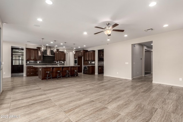 unfurnished living room featuring visible vents, baseboards, ceiling fan, recessed lighting, and a sink