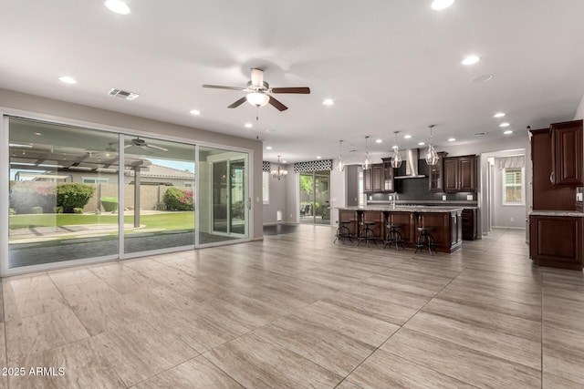 living area with recessed lighting, ceiling fan, and visible vents