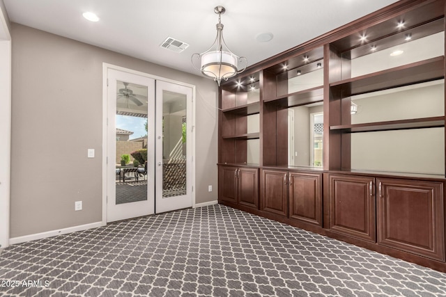 carpeted empty room featuring a healthy amount of sunlight, baseboards, french doors, and visible vents