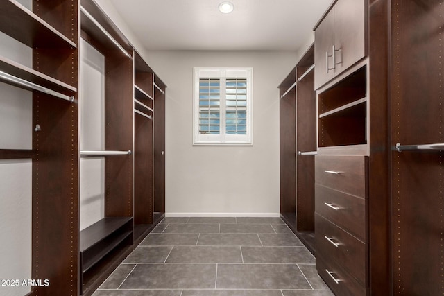 spacious closet featuring dark tile patterned flooring
