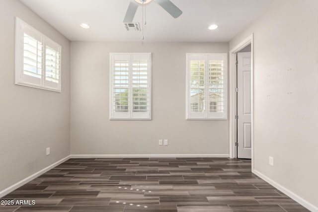 empty room with baseboards, ceiling fan, dark wood finished floors, and visible vents