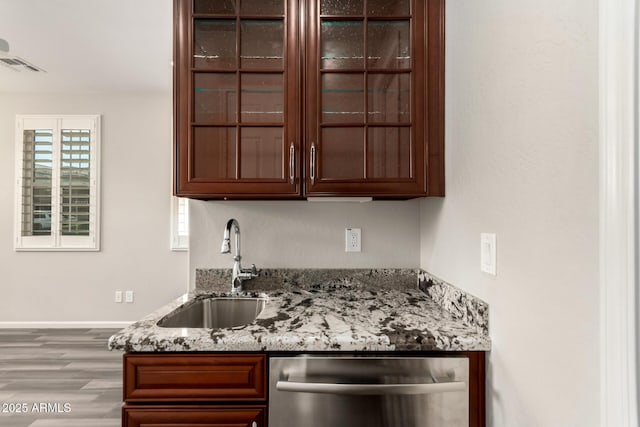 bar featuring stainless steel dishwasher, visible vents, wood finished floors, indoor wet bar, and a sink