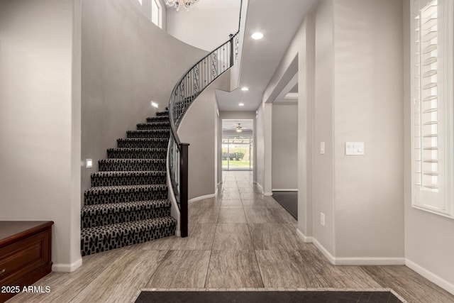 foyer featuring recessed lighting, baseboards, and stairway