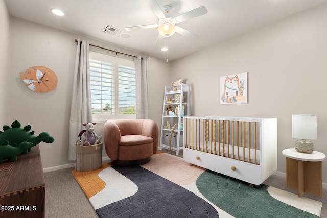 carpeted bedroom featuring ceiling fan, visible vents, baseboards, a crib, and recessed lighting