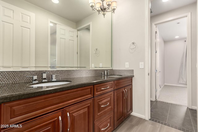 full bath with backsplash, double vanity, baseboards, and a sink