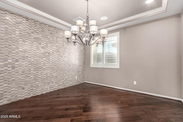 unfurnished dining area with an inviting chandelier, a tray ceiling, dark wood-style flooring, and visible vents