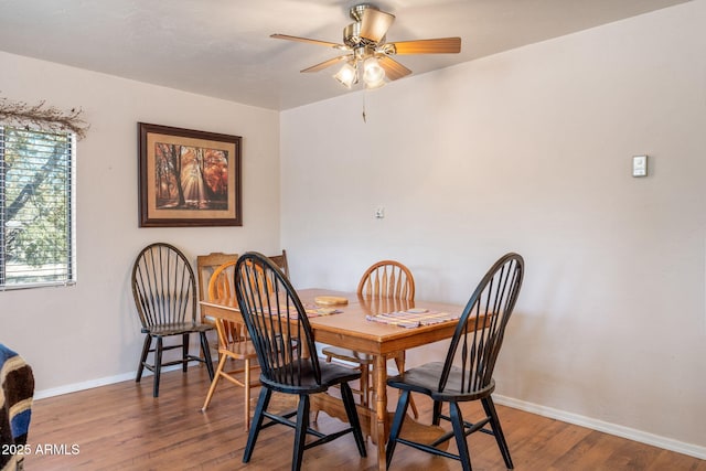 dining space featuring wood finished floors, baseboards, and ceiling fan