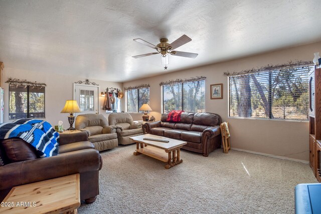 living area with light carpet, a textured ceiling, a wealth of natural light, and a ceiling fan